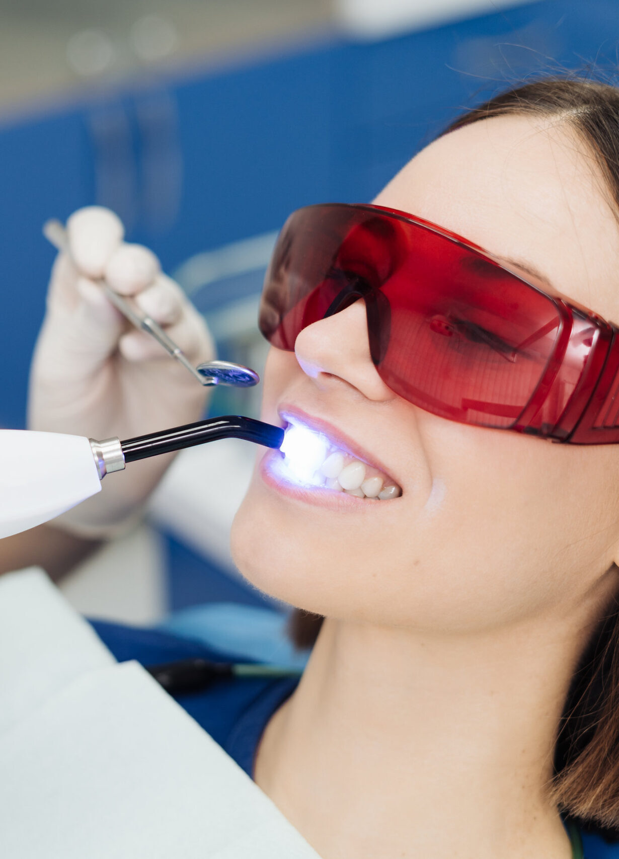 Close-up portrait of a female patient visiting dentist for teeth whitening in clinic