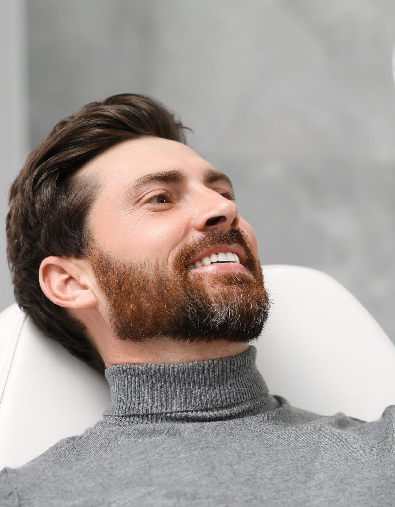 Man looking at his new dental implants in mirror indoors